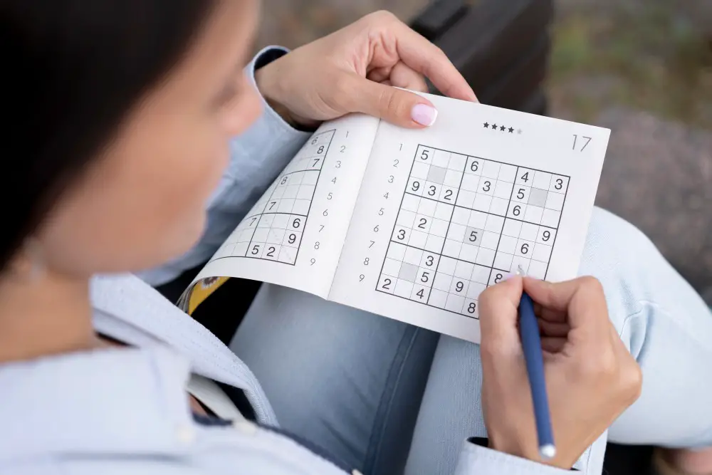 This photo depicts a woman playing a Sudoku game using the pencil marks technique.