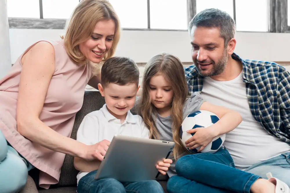 How to Ensure Internet Safety for Your Kids: This photo depicts parents and their kids surfing the internet with a tablet PC. 